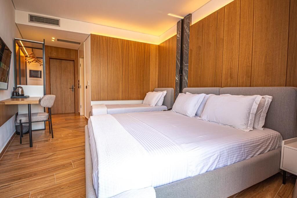 Una habitación de hotel moderna con una cama grande, un escritorio y una silla.