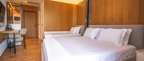 Una habitación de hotel moderna con una cama grande, un escritorio y una silla.