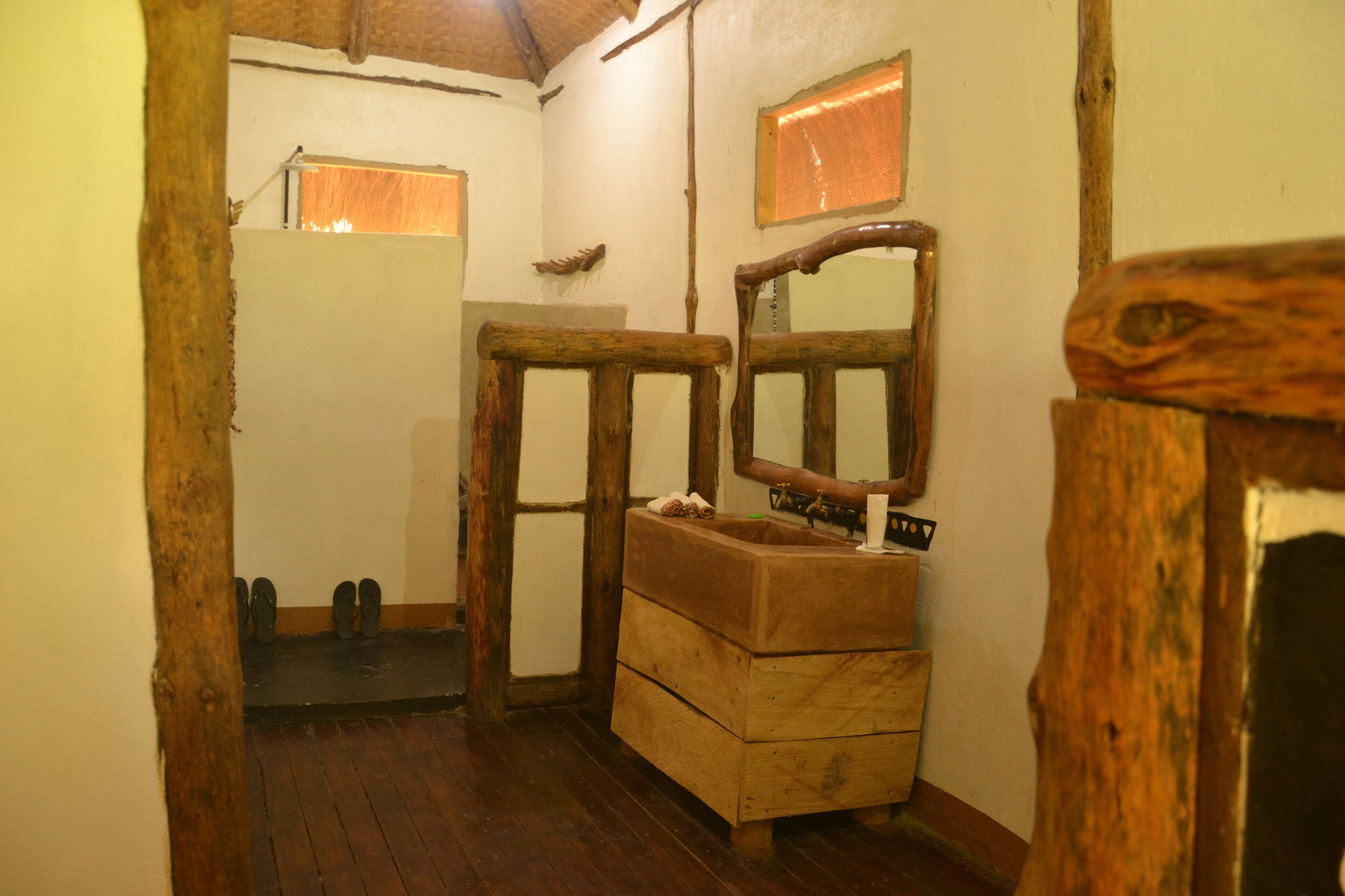 Une salle de bain rustique avec des éléments en bois, un banc en bois et un miroir.