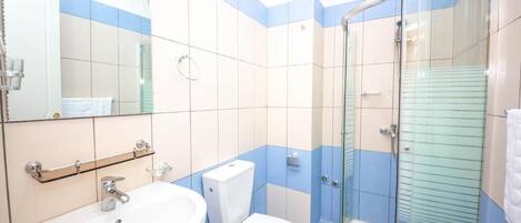 Un baño con lavabo, inodoro y cabina de ducha de vidrio.