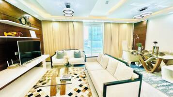 Departamento Deluxe, 2 habitaciones, vista a la ciudad | Área de sala de estar | Smart TV de 65 pulgadas con canales vía satélite