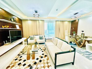 Căn hộ Deluxe, 2 phòng ngủ, quang cảnh thành phố | Khu phòng khách | Smart TV 65-inch có truyền hình vệ tinh 