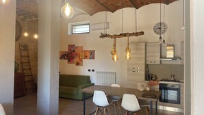 Une cuisine moderne équipée d’une cuisinière à gaz, d’un four et d’un coin repas avec une table et des chaises en bois.