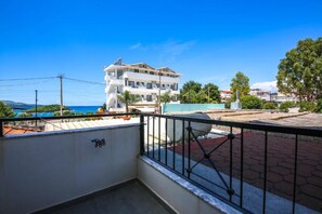 A multi-story building with balconies, a paved area, and a view of the sea. - Rumani 3 Islands Hotel (Ksamil)