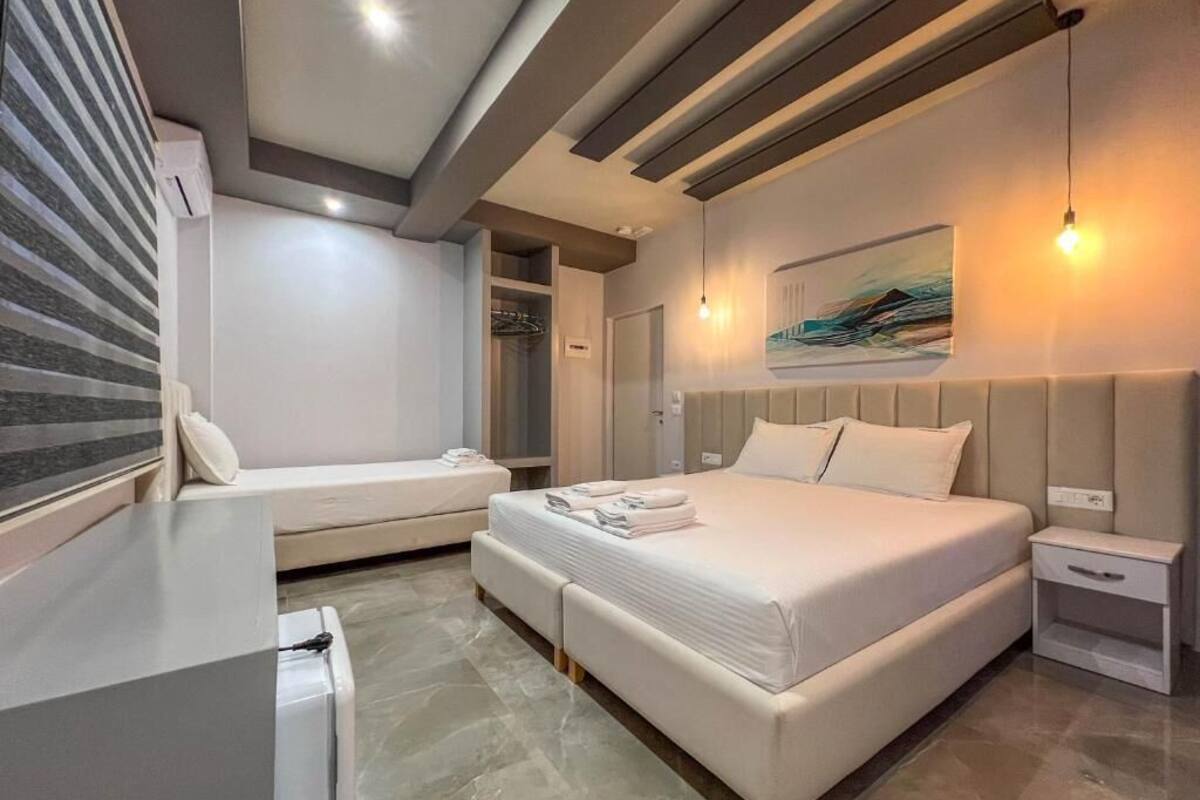 Un dormitorio moderno con una cama grande, una mesita de noche y un cuadro colgado en la pared.