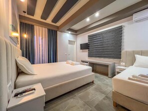 A modern hotel room with a large bed, a smaller bed, a desk, and a TV. - Rumani 3 Islands Hotel (Ksamil)