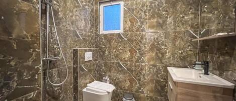 Un baño con ducha, inodoro y lavamanos.