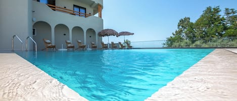 Una piscina al aire libre de temporada, sombrillas