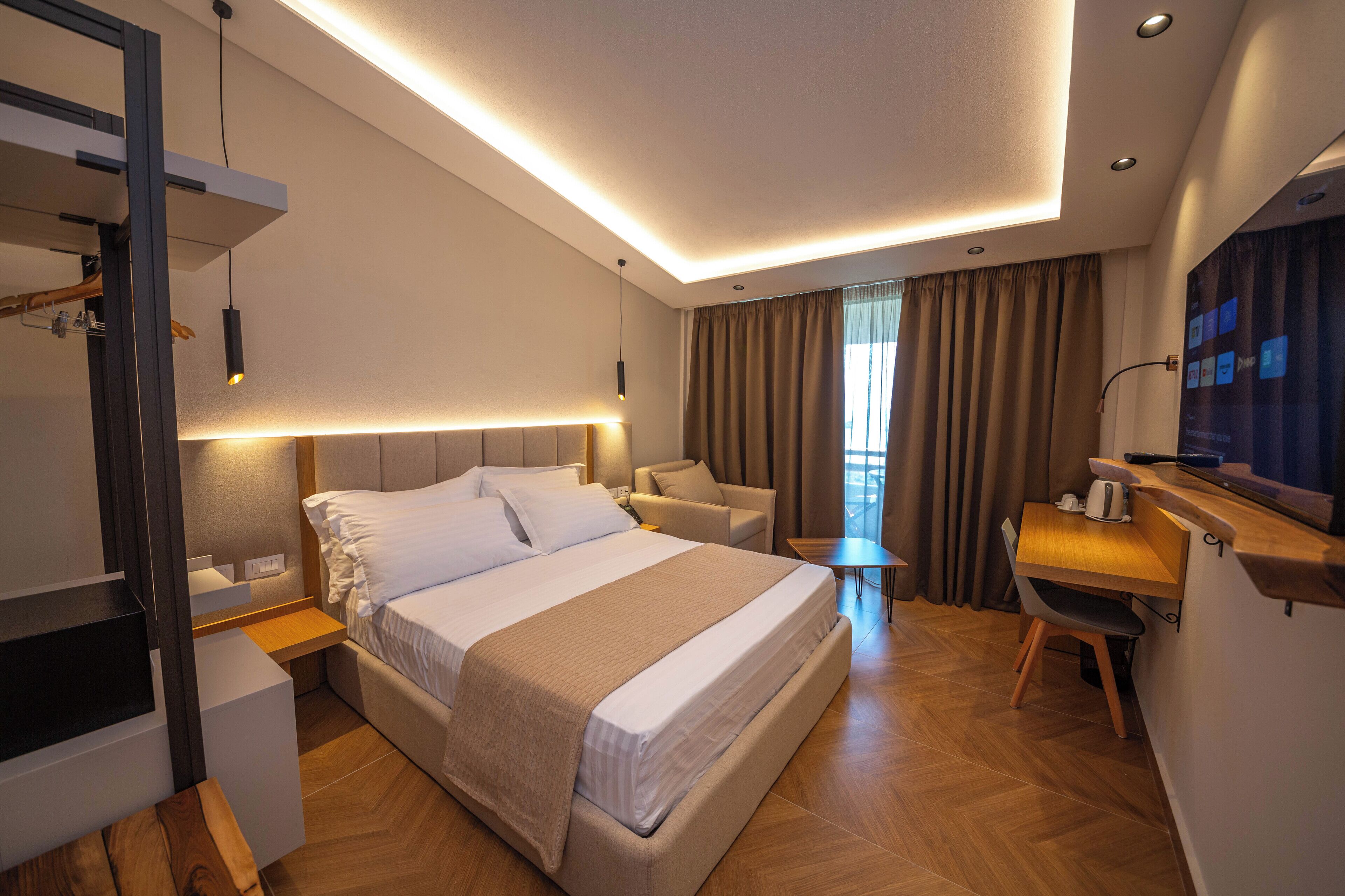 Una habitación de hotel moderna con una cama grande, un escritorio y una silla.