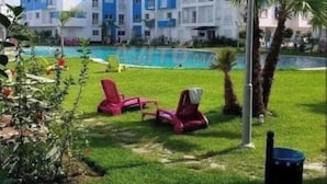 Un hotel amb diverses plantes, una piscina i zones d'estar a l'aire lliure.