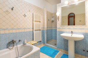 Kombinasi shower/bathtub, pengering rambut, kloset, dan handuk