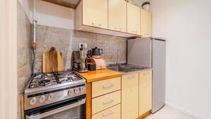 Une cuisine équipée d’une cuisinière à gaz, d’un four, d’un plan de travail en bois et d’un réfrigérateur.