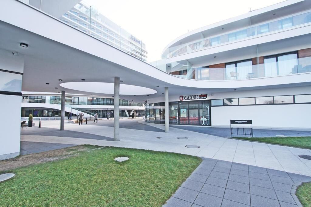 A modern building with a curved facade, a glass entrance, and a sign reading "BERLIN KERAM".