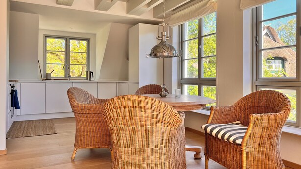 A modern kitchen with large windows, wicker chairs, and a hanging light fixture. - Sommerby Sky - near the beach, shower, desk, top floor, EV charging station (Brodersby)