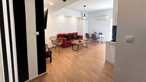 A modern living space with a red sofa, wooden dining table, and a white brick wall.