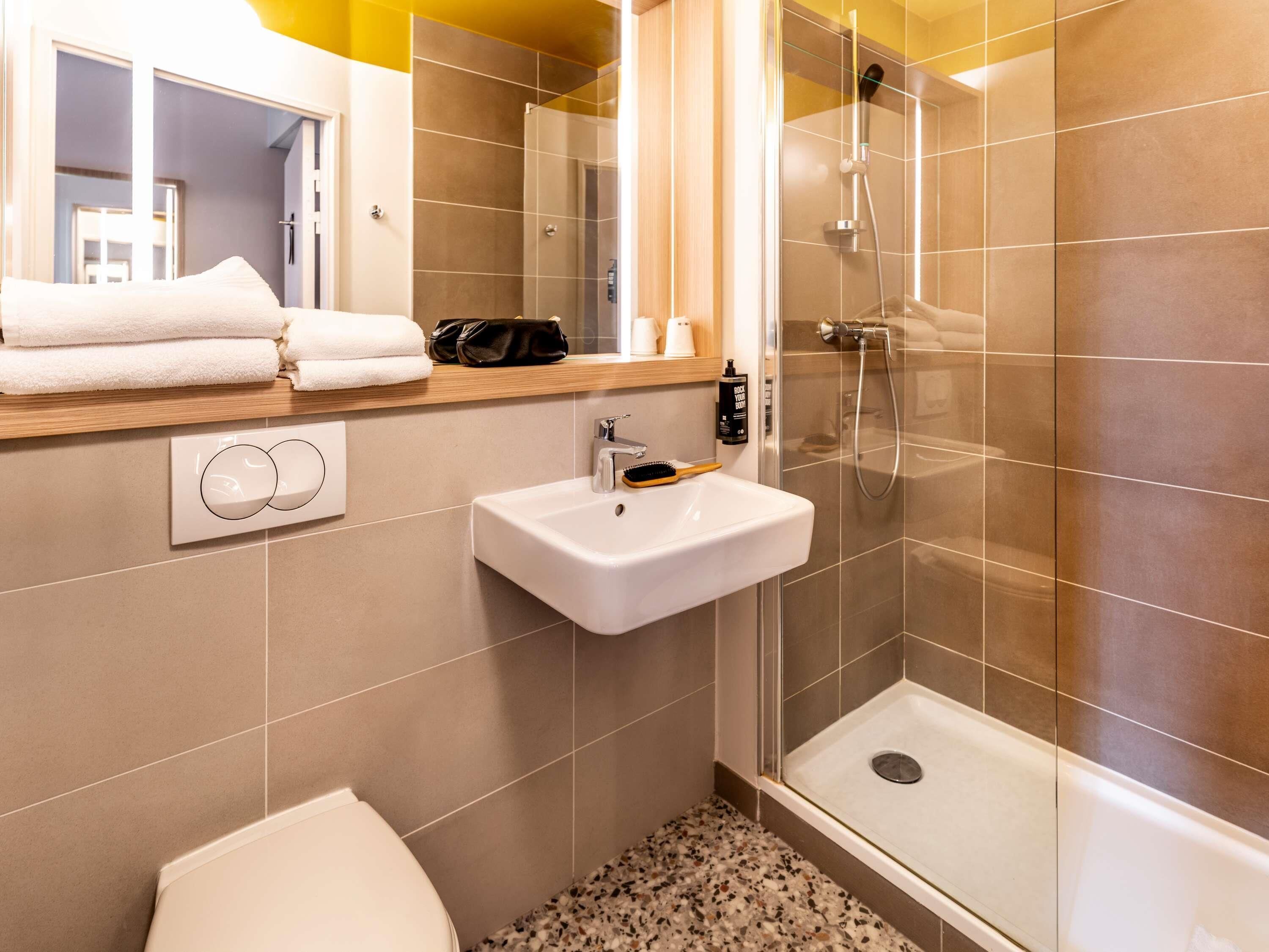 Un baño moderno con ducha, lavabo e inodoro.