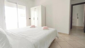 A hotel room with a bed, a wardrobe, and a bathroom visible through an open door. - Maison de Luxe Layla (Martil, Tangier-Tétouan-Al Hoceima,)