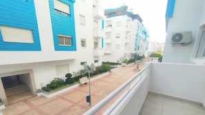 A residential building with a balcony, a tiled courtyard, and a small entrance. - Maison de Luxe Layla (Martil, Tangier-Tétouan-Al Hoceima,)