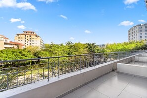 A modern apartment building with a balcony, surrounded by lush greenery and other residential buildings. - Mayfair 246 (Cape Town)