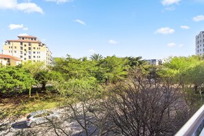 A residential area with multi-story buildings, dense greenery, and a parked car. - Mayfair 246 (Cape Town)