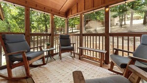A covered outdoor seating area with wooden furniture and large windows. - 4 Master Suites! By StoneBridge Pool! SDC! (Branson West)