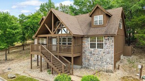 A lodge with a stone facade, wooden balconies, and a staircase leading to the entrance. - 4 Master Suites! By StoneBridge Pool! SDC! (Branson West)