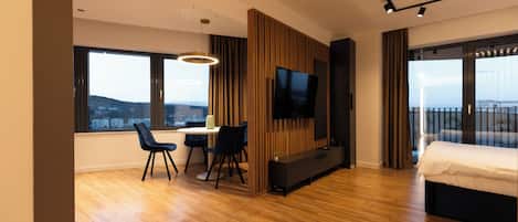 Departamento Deluxe, balcón, vista a la ciudad | Área de sala de estar | Televisión de pantalla plana