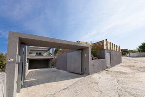 Een hek toegangt een gebouw met een beton gevel en een garage.