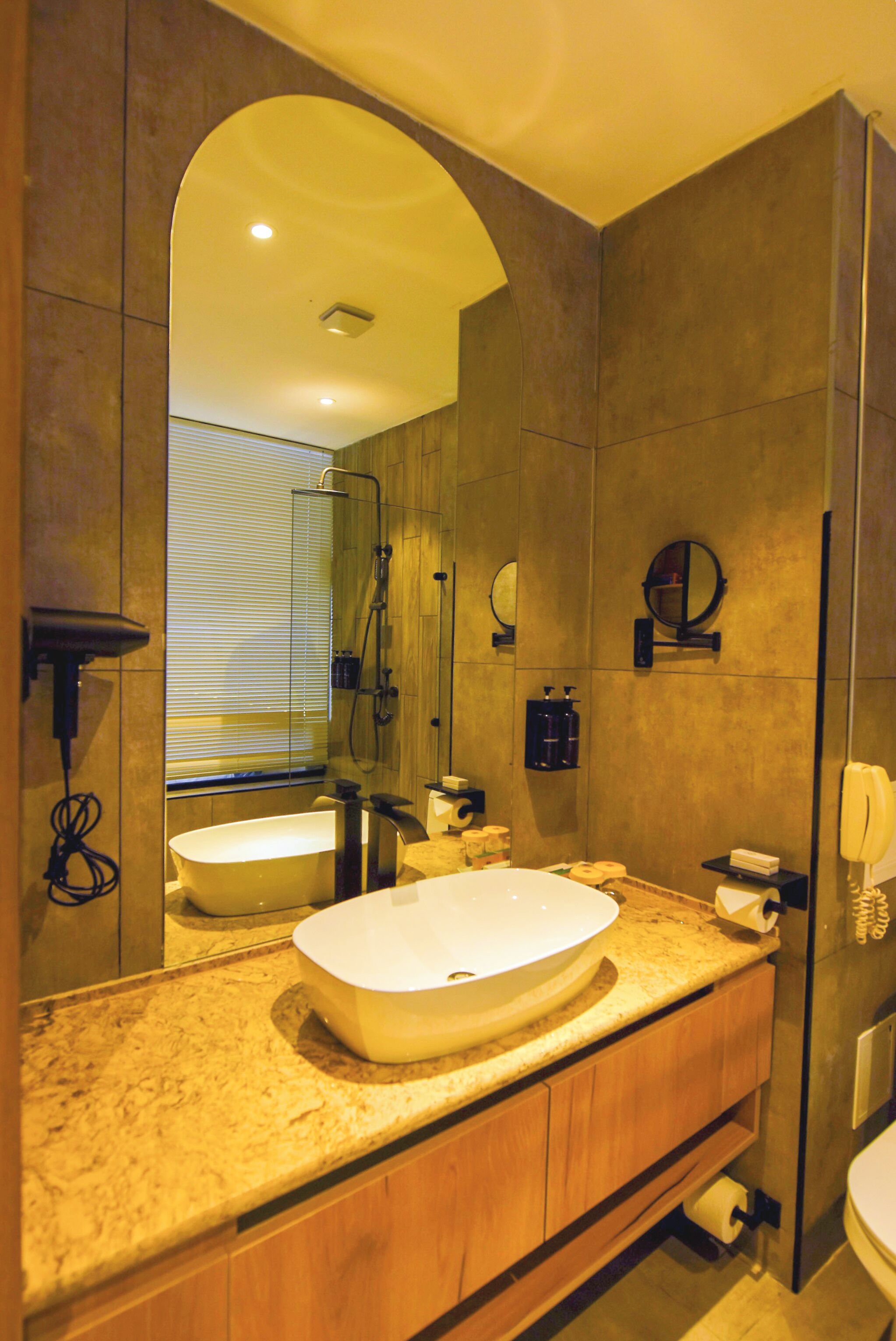 Une salle de bain moderne avec un grand miroir, une baignoire sur pieds et un meuble-lavabo avec un évier.