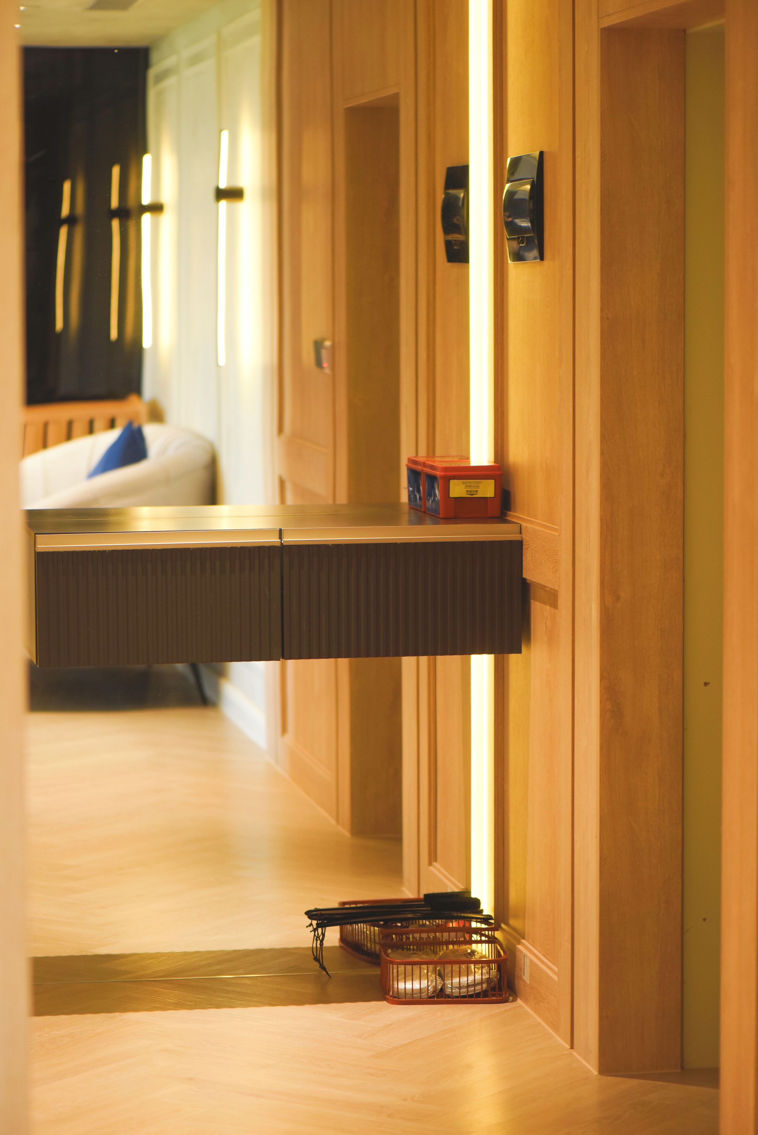 Un pasillo de hotel con paneles de madera, un banco y una pequeña mesa con una caja encima.