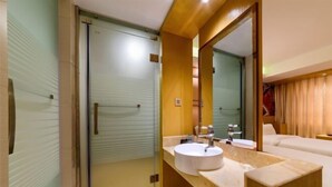 Une salle de bain moderne avec une douche à parois de verre, un meuble-lavabo en bois et un grand miroir.