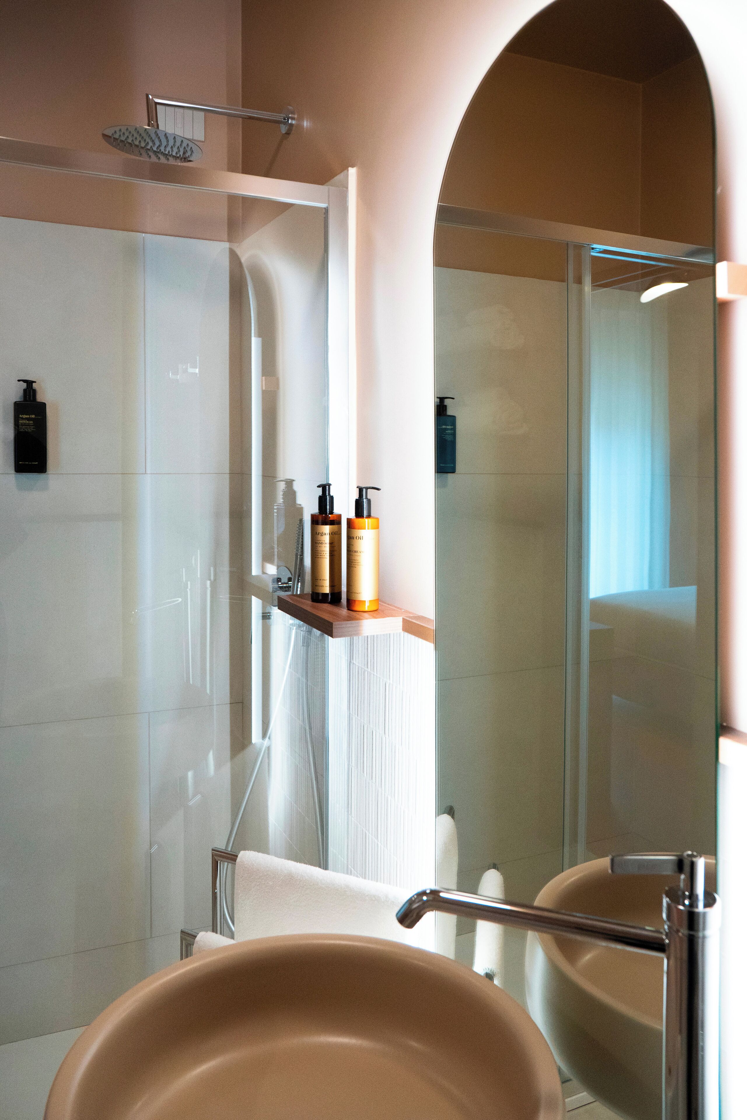 A modern bathroom with two sinks, a shower, and a mirror.