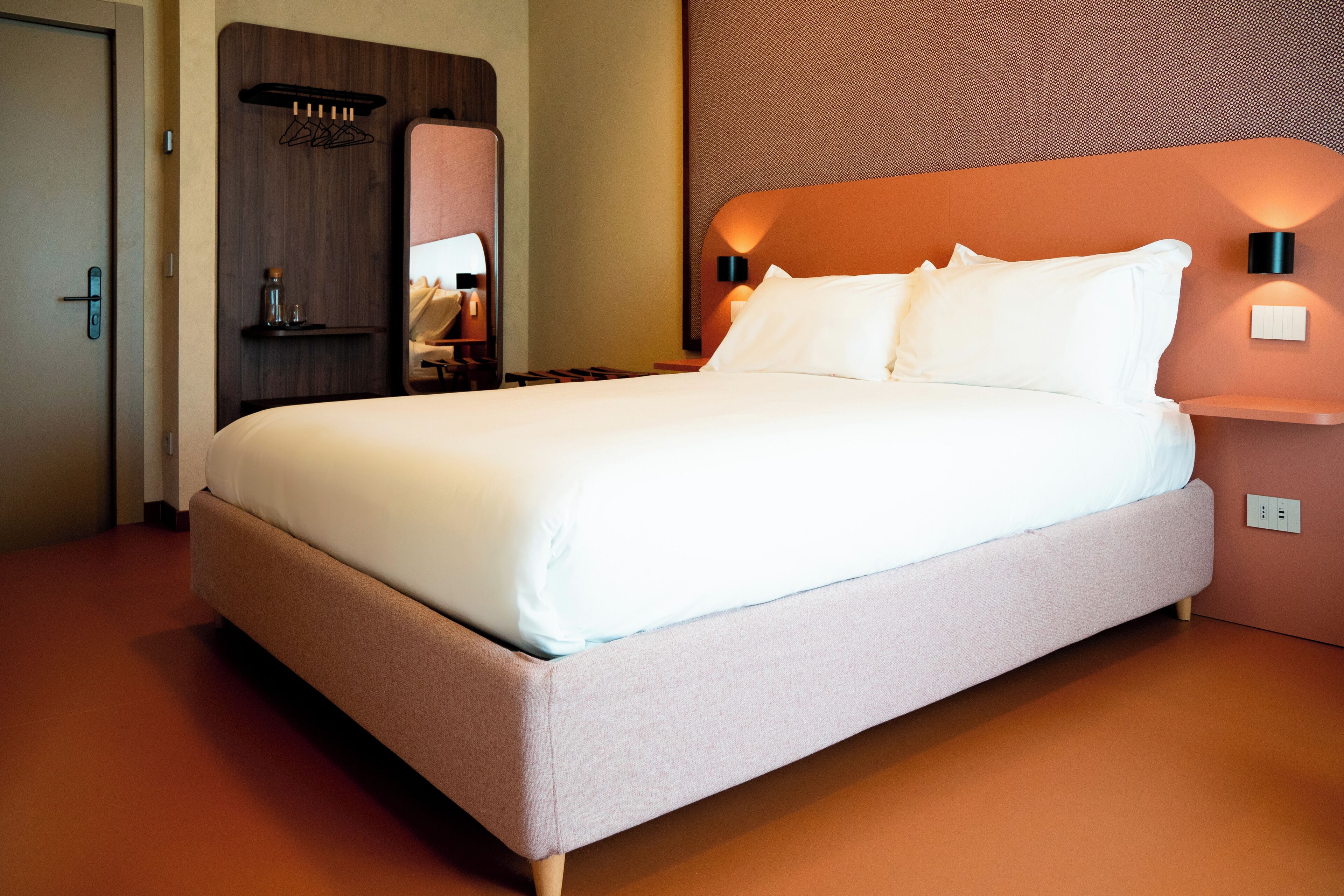 Una cama grande con ropa de cama blanca en una habitación de hotel.