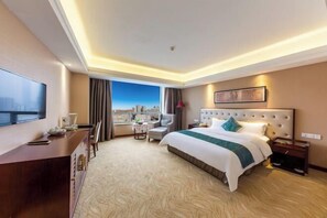 A hotel room with a large bed, a desk, a chair, a TV, and a window with a city view. - Huatian Hotel(Wuhan Xudong Metro Station) (Wuhan)