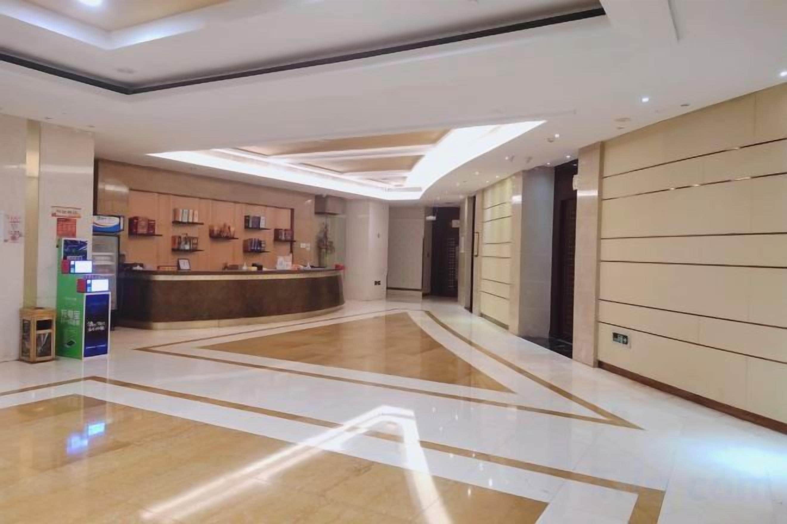 A hotel lobby with a reception desk, a digital check-in kiosk, and a clean, modern design.