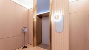 A modern elevator interior with a metallic finish and a digital display showing the number 1. - HanTing Hotel (Zhangjiagang Jingang RT-MART Branch) (Zhangjiagang)