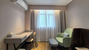 A modern hotel room with a desk, two chairs, a sofa, and a large window with curtains. - HanTing Hotel (Zhangjiagang Jingang RT-MART Branch) (Zhangjiagang)