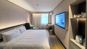 A hotel room with a bed, a desk, a TV, and a shelf with items. - HanTing Hotel (Zhangjiagang Jingang RT-MART Branch) (Zhangjiagang)