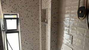 A bathroom with a shower, a toilet, and a sink.