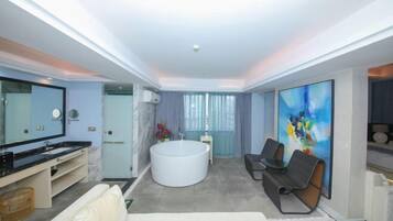 Un baño moderno con bañera, tocador con espejo y un cuadro grande en la pared.