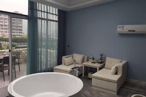 A modern living room with a large bathtub, a sofa set, and a balcony with a view. - Fuerte Chain Hotel Leqing Yundu (Yueqing)