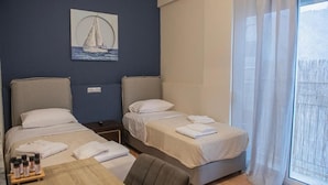 Ein Hotelzimmer mit zwei Betten, einem Holztisch und einem Bild eines Segelbootes an der Wand.