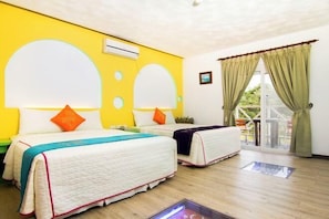 A hotel room with two beds, a yellow accent wall, and a view through a glass door. - Ocean Star Hostel (Pingtung)