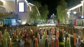 A nighttime view of a pedestrian bridge with decorative elements and a water feature.