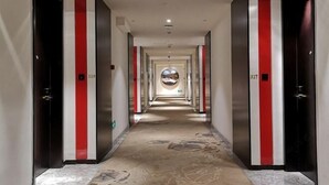 A hotel corridor with a central circular skylight, red and white striped walls, and numbered doors. - Yiwenge Hotel (Changshu)