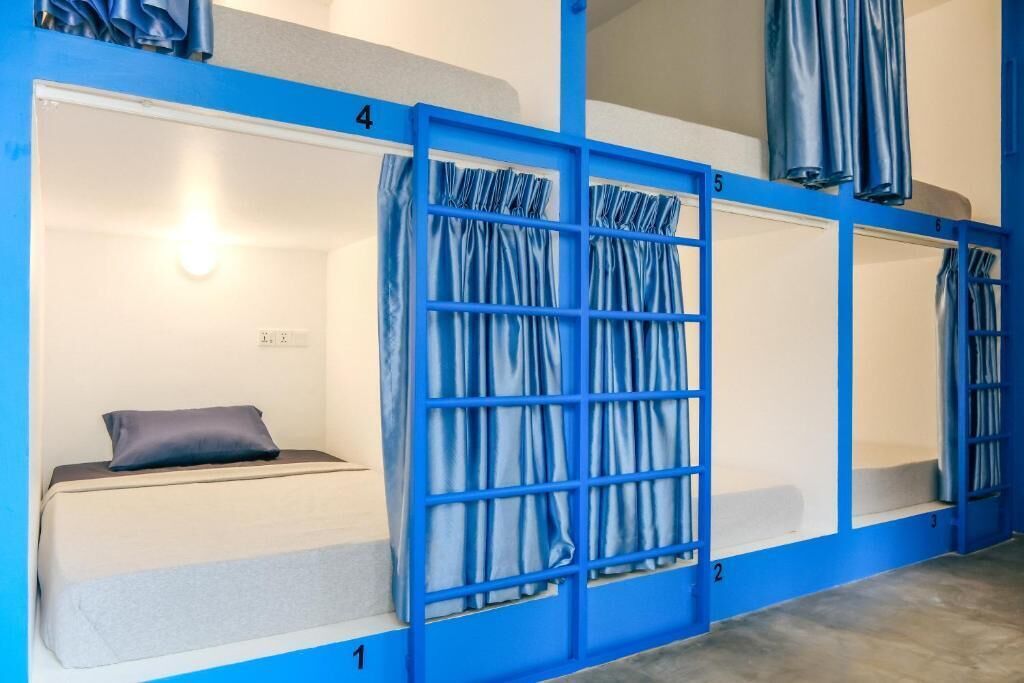 Habitación tipo dormitorio con literas numeradas del 1 al 5, y una cortina divisoria entre las literas 4 y 5.