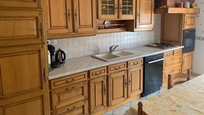 Una cocina con armarios de madera, un lavamanos, una estufa y un lavavajillas.