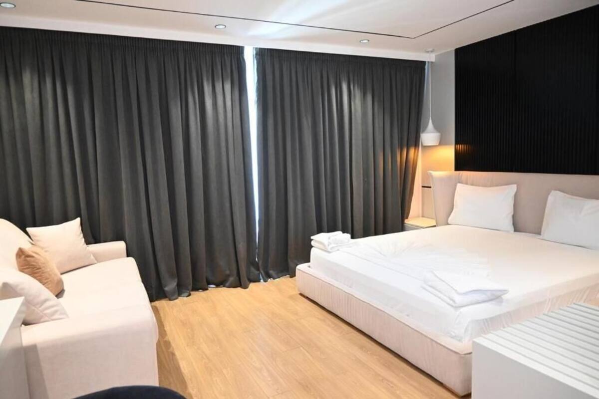 Una habitación de hotel moderna con una cama grande, un sofá y un escritorio.