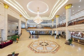 A spacious lobby with a central chandelier, marble flooring, and a staircase leading to an upper level. - Zhaojun Mountain Villa (Xingshan High-speed Railway Station) (Xingshan)