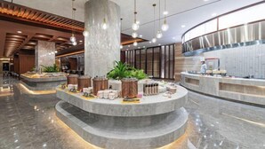 A modern lobby with a central circular seating area, a reception desk, and a large pillar. - Zhaojun Mountain Villa (Xingshan High-speed Railway Station) (Xingshan)